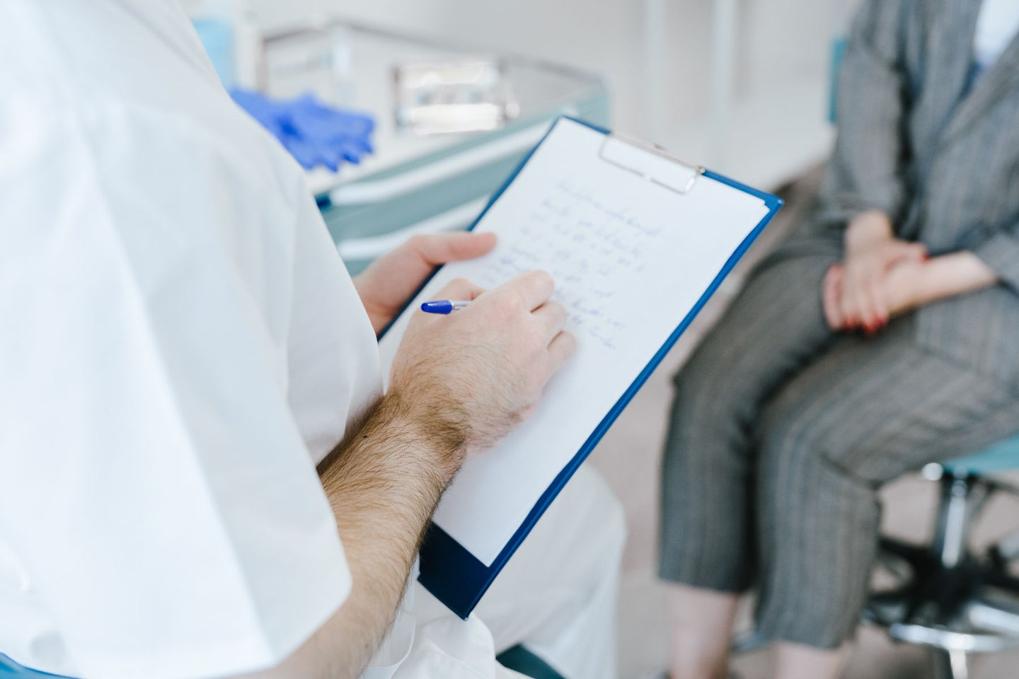 A medical professional writing notes during a consultation