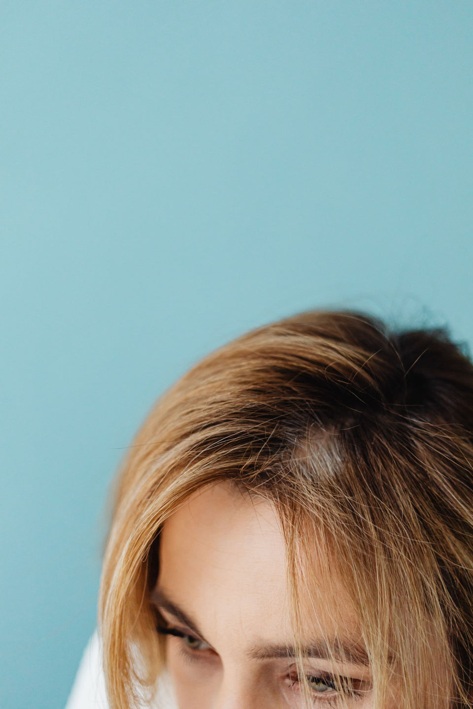 Close view of a woman’s central hair part and forehead