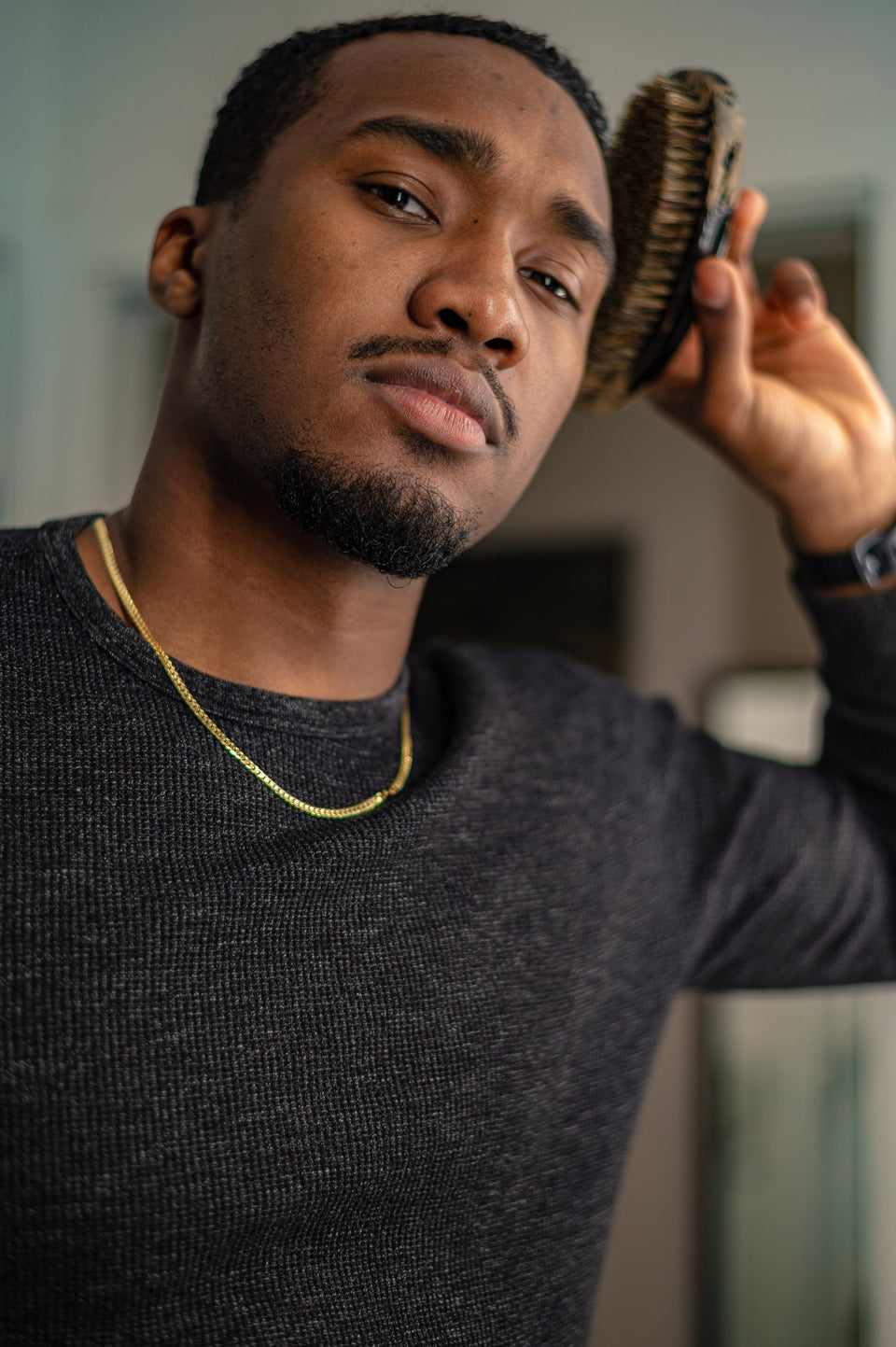 A man brushing short hair near the hairline