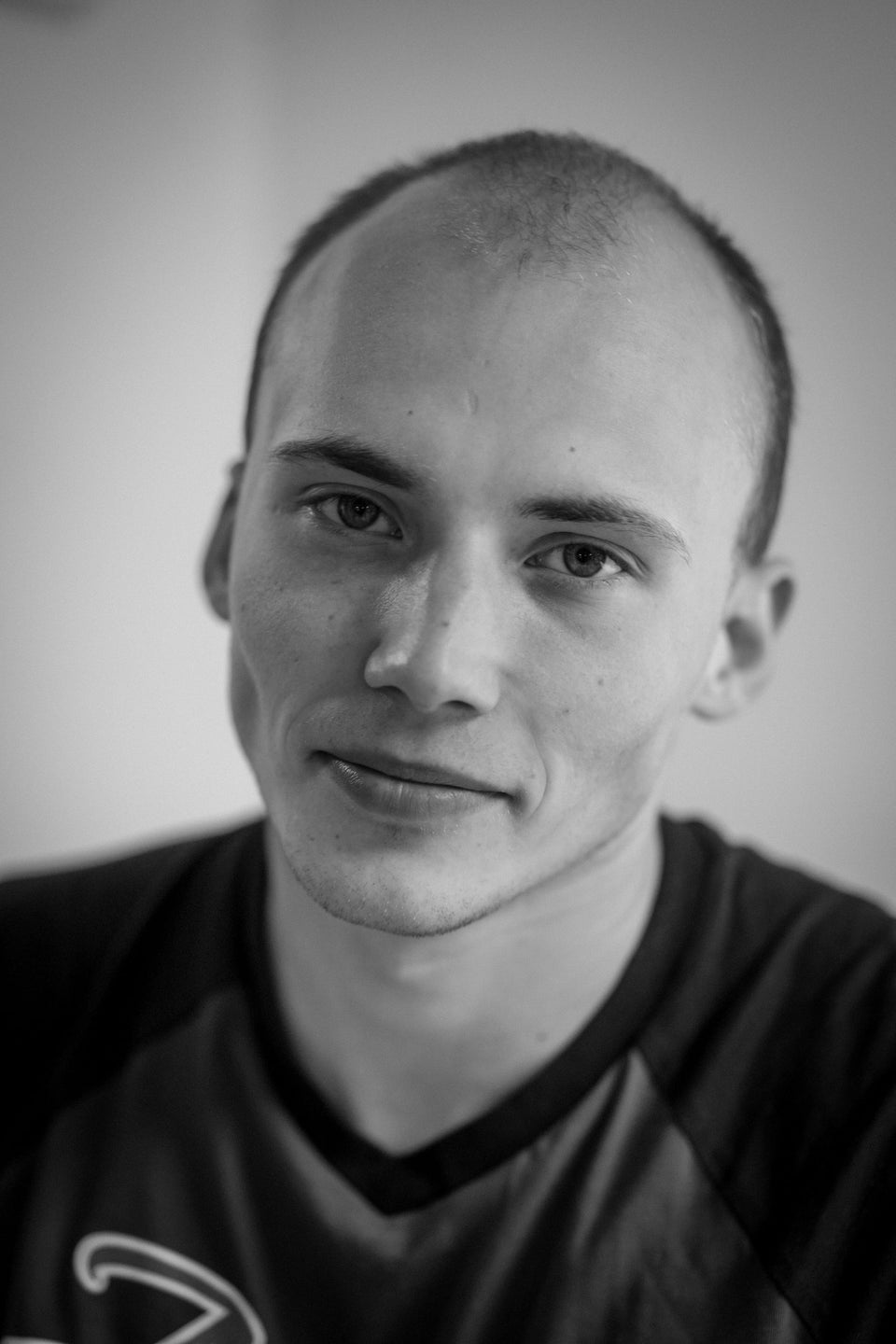 A black and white portrait of a man with short hair
