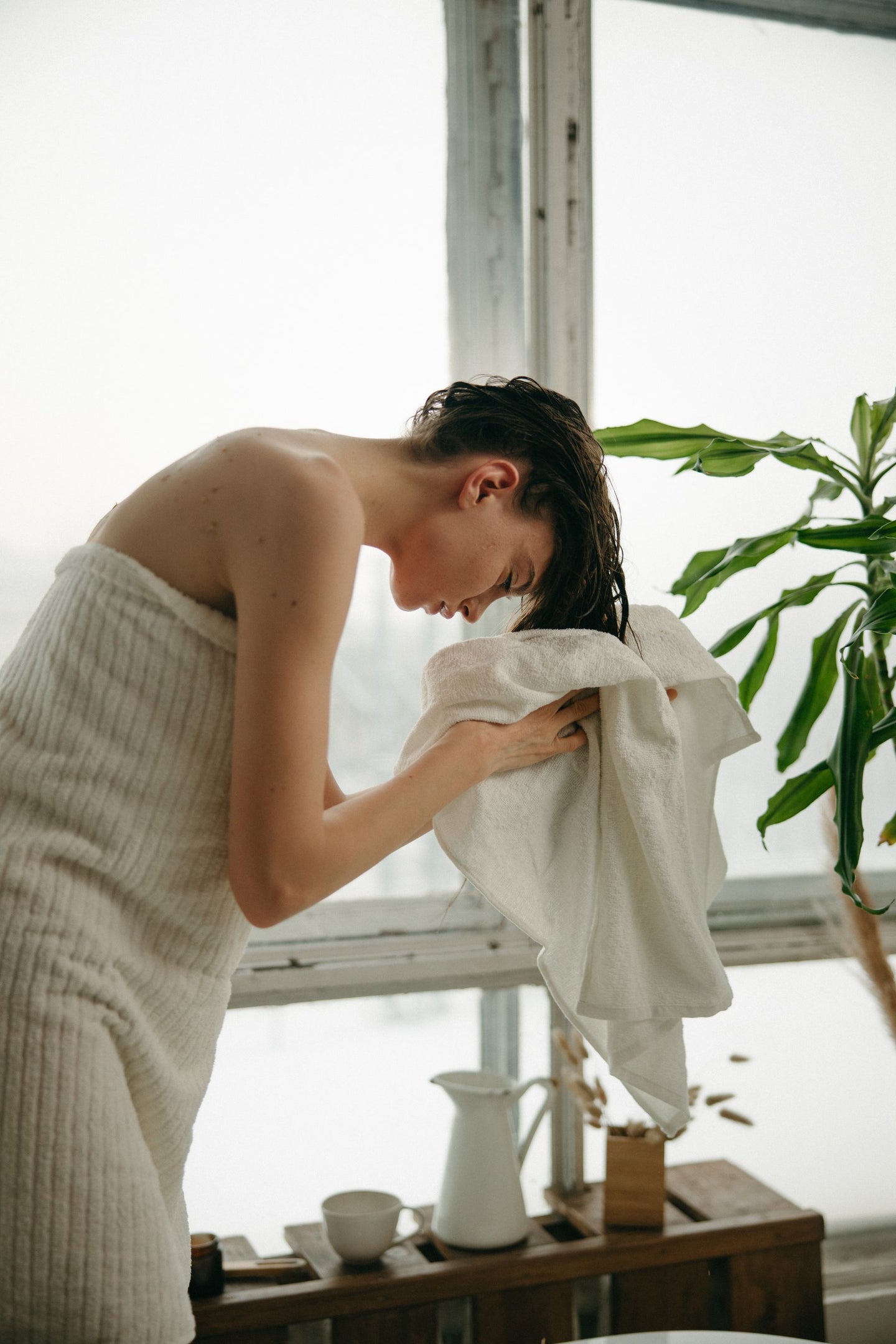 A woman using a towel on freshly washed hair
