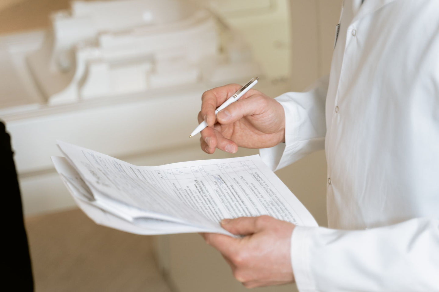 A clinician holding a pen while reviewing documents